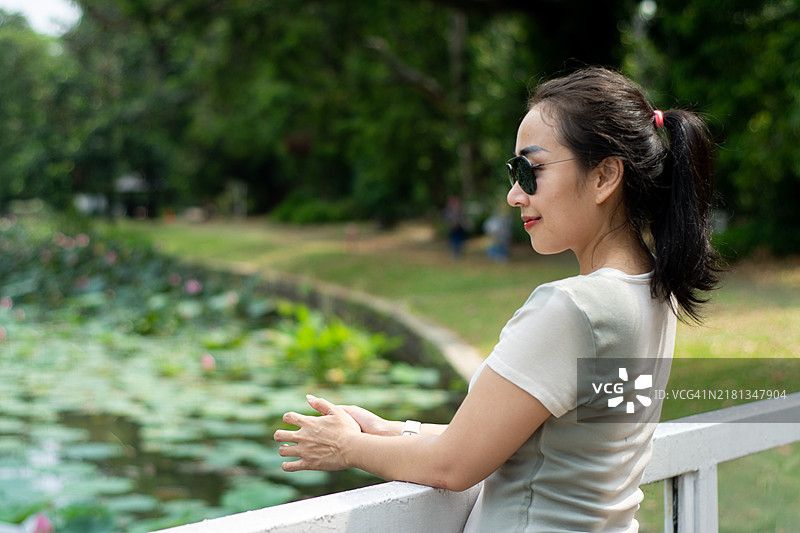 亚洲女性在风景优美的公园里戴着太阳镜放松身心的肖像 | 生活方式图片素材