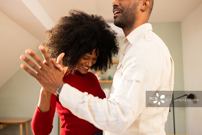 快乐的拉丁夫妇在家享受音乐和舞蹈图片素材