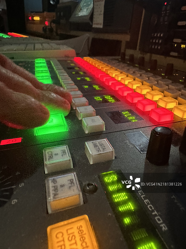 中年男子在他的音响工作室操作调节不同音轨的桌子图片素材