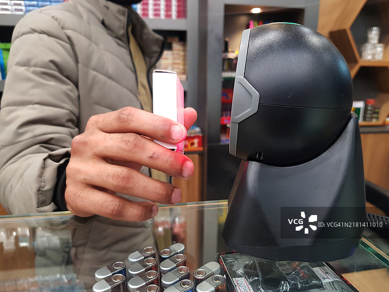 一名销售员在零售店使用条形码和二维码扫描器扫描产品价格。图片素材