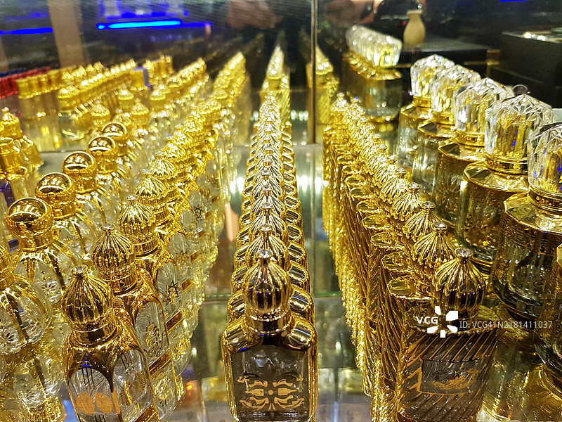 阿拉伯风格的金色香水和乌德香料瓶整齐排列在香水市场出售。图片素材