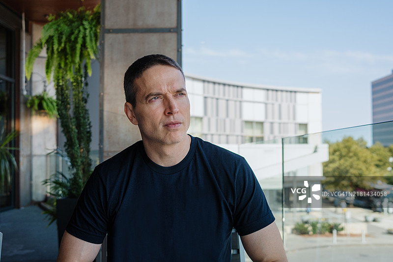 男子在阳光明媚的日子里坐在户外餐厅图片素材