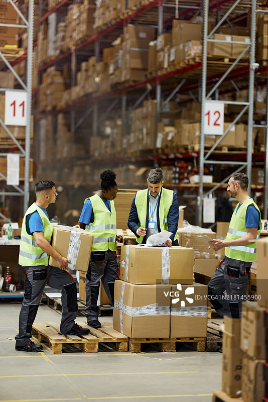 男检查员及其多元化的员工在储藏室里检查清单图片素材