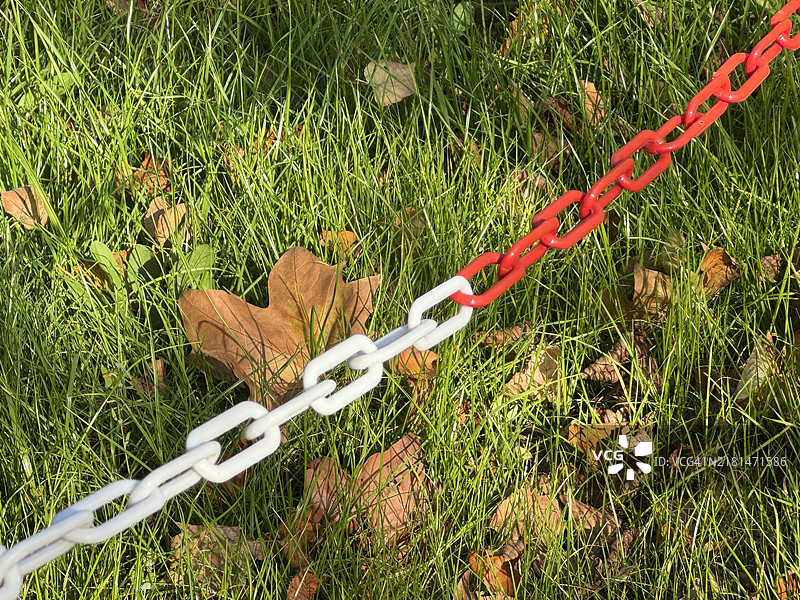 红白色路障链与草地背景图片素材