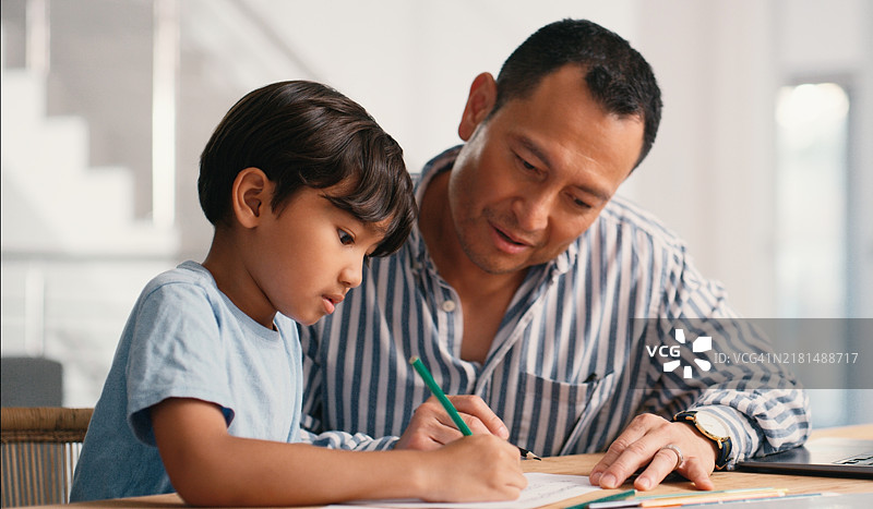 日本父亲指导儿子在家写作业，提供教育、学习和支持图片素材