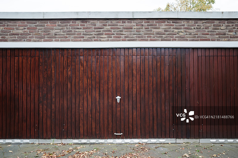带砖墙背景的关闭木质车库门图片素材