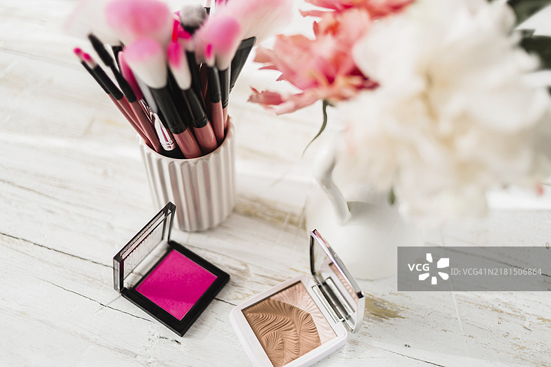 鲜花旁的化妆刷图片素材