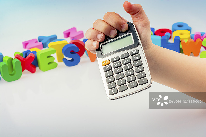 手持小计算器，白色背景上带有彩色字母图片素材