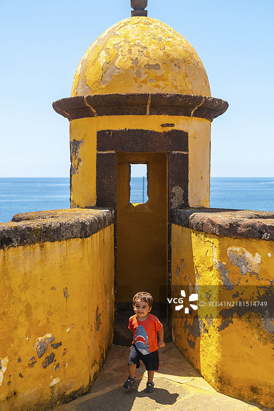 在丰沙尔圣地亚哥堡垒的瞭望塔里玩耍的男孩，马德拉群岛图片素材