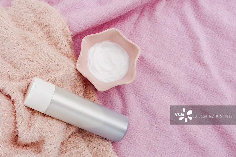 俯视粉色背景下的瓶装身体乳图片素材