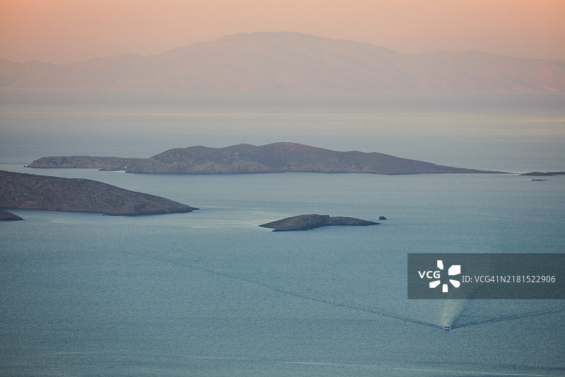 希腊基克拉泽斯群岛阿莫尔戈斯岛日出时的海岛和船只景观图片素材