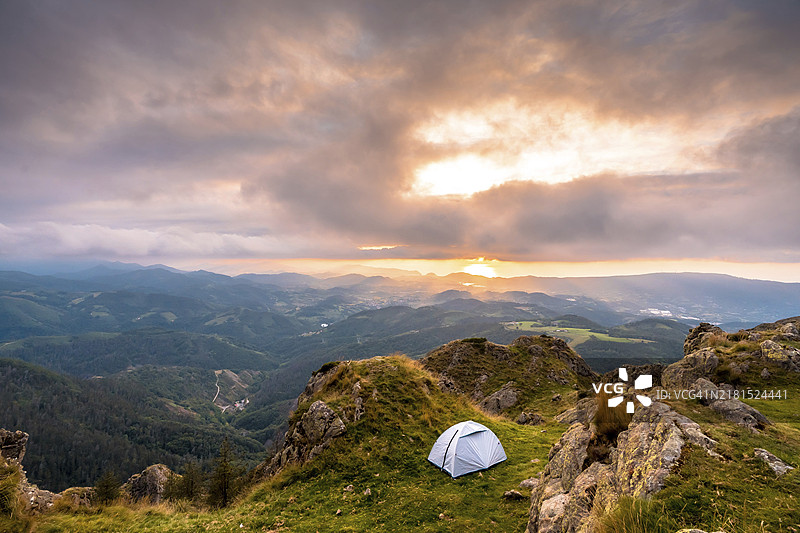 山顶日落时分的野营，在山区长途跋涉后露天睡觉图片素材