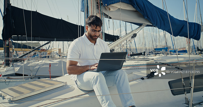 在船上的男子使用笔记本电脑进行假日旅行、检查清单和海上安全图片素材
