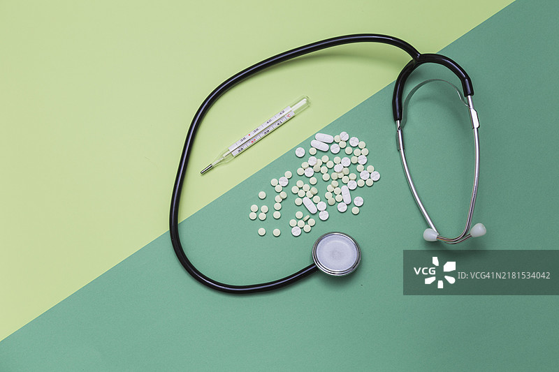 药品、体温计、听诊器双色背景高角度视图图片素材