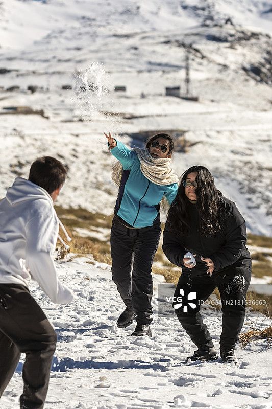 在西班牙安达卢西亚的内华达山脉滑雪胜地，拉丁裔家庭在阳光明媚的日子里玩雪球图片素材