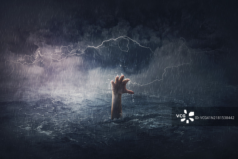 溺水的手臂。在飓风暴风天气下，一个人沉入海底的超现实和戏剧性场景。人们在危险情况下需要帮助。绝望、沮丧和失败的比喻图片素材