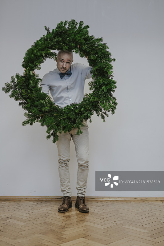 男人拿着冷杉花环图片素材