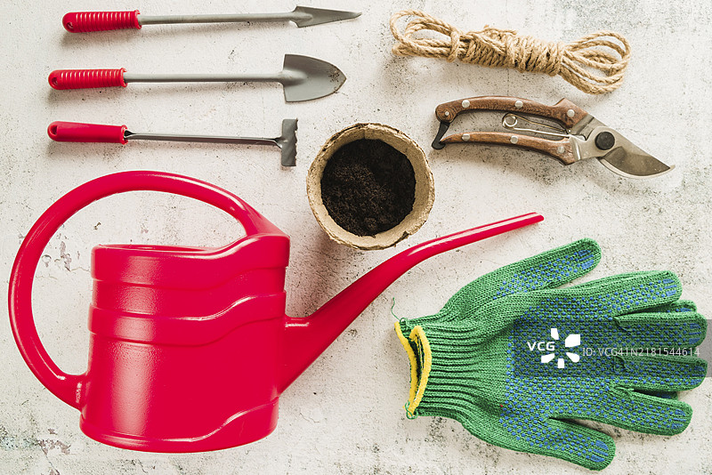 园艺设备：浇水壶、泥炭盆、修枝剪、绳子、园艺手套、水泥背景图片素材