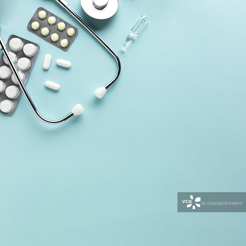 听诊器和蓝色背景下的药品图片素材