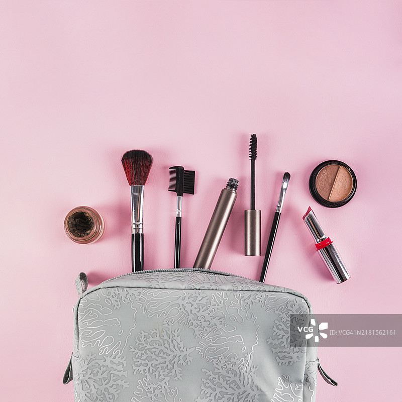 化妆品从包里溢出粉红色背景图片素材