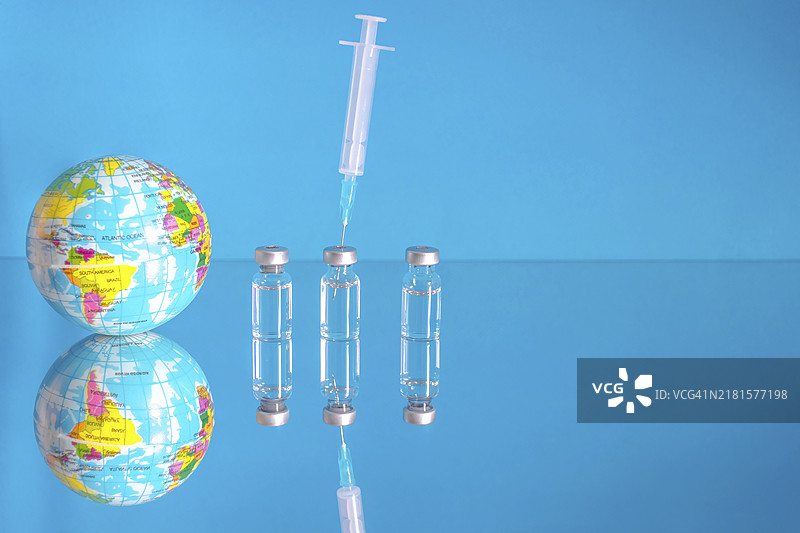 疫苗瓶和注射器，用于治疗COVID-19、流感或感冒，全球大规模接种冠状病毒疫苗，全球免疫概念与第三次加强剂量图片素材