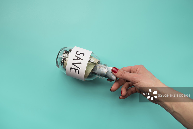 手把钱放进罐子里图片素材