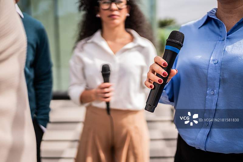 户外一位女记者手持麦克风的特写镜头图片素材