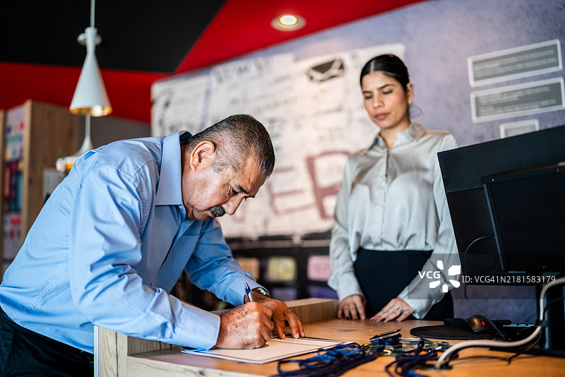 酒店大堂中注册会议的高级商务会议参与者图片素材