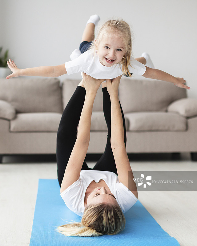 母亲在家与快乐的孩子一起锻炼的正面图图片素材