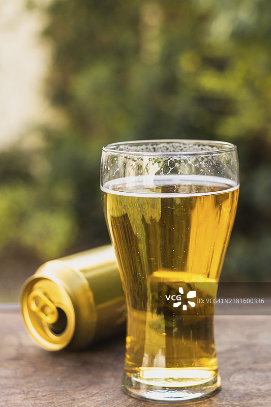 啤酒罐旁的啤酒玻璃杯图片素材