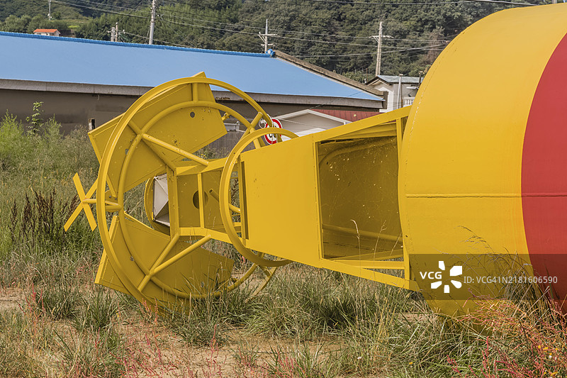 渔村草地上的黄色和红色海洋浮标底部图片素材
