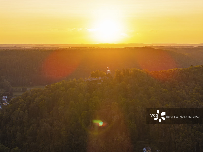 日落时分的森林山丘，天空呈现温暖的橙色调，德国黑森林图片素材