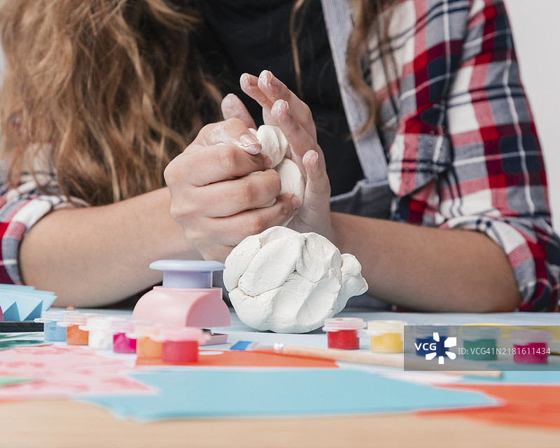 年轻女子用手揉搓白色黏土特写图片素材