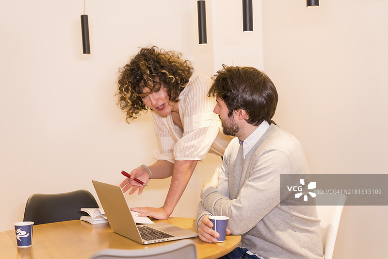 女老板在办公室的桌旁指导员工图片素材