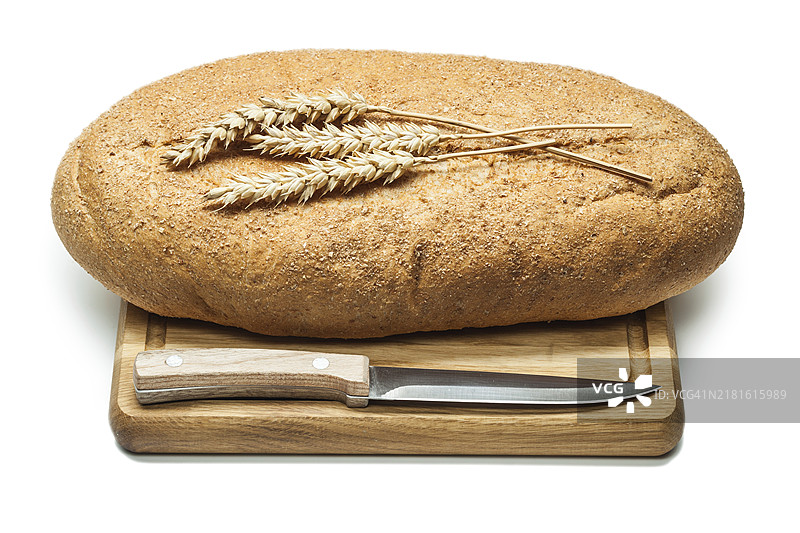 带厨房刀和麦穗的切菜板上的面包图片素材