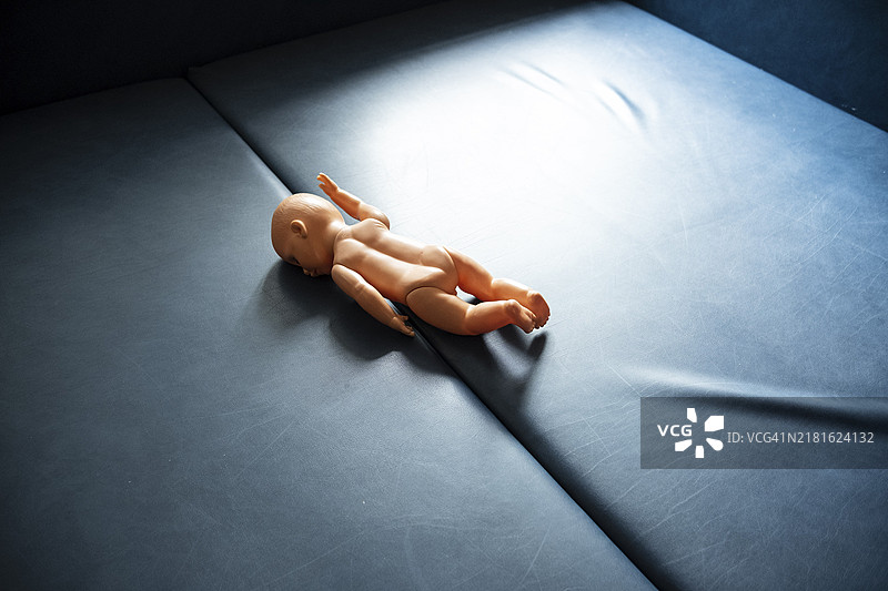 躺在蓝色底座上的玩偶，象征性图像图片素材
