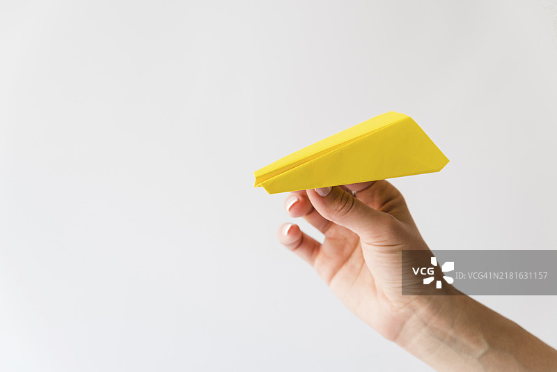 手持黄色纸飞机图片素材