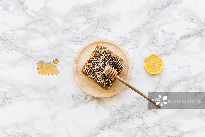 蜂蜜勺、蜂巢柠檬片与白色大理石背景图片素材