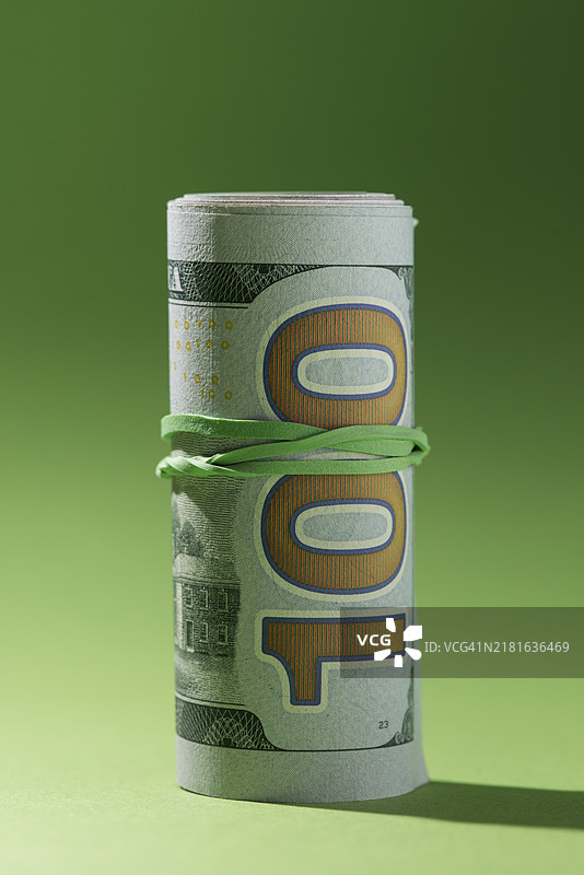 卷起来的钞票，绿色背景图片素材