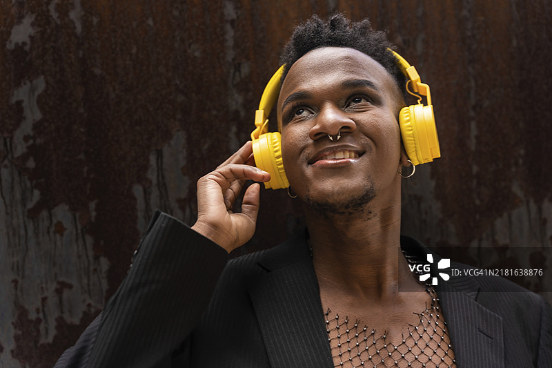 戴黄色无线耳机听音乐的黑人男子肖像图片素材