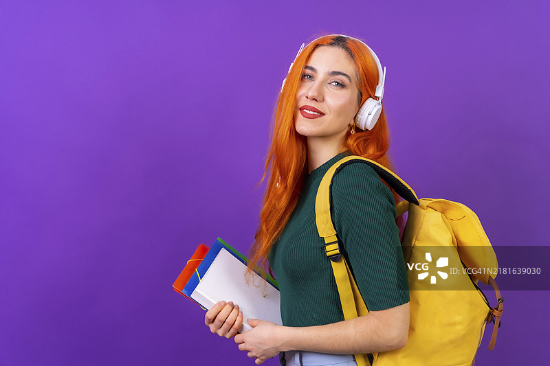 在紫色背景上跳舞的红发女大学生，返校季图片素材