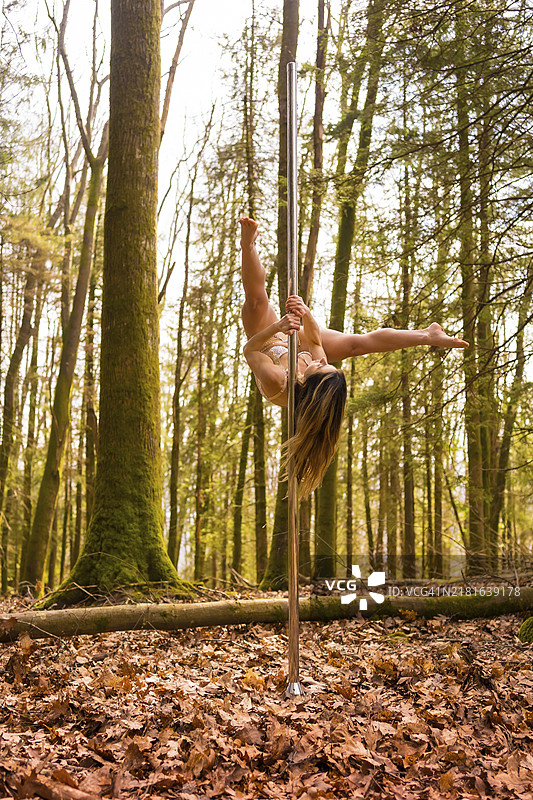 在森林里跳钢管舞的金发白人女子图片素材