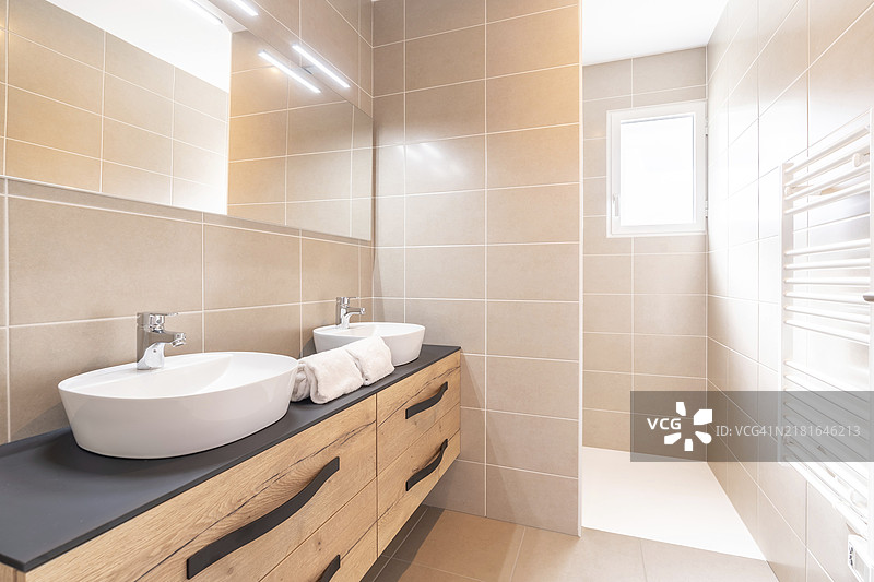 家庭浴室，明亮的新浴室内部，配有瓷砖玻璃淋浴、梳妆台、木制设计的内饰图片素材