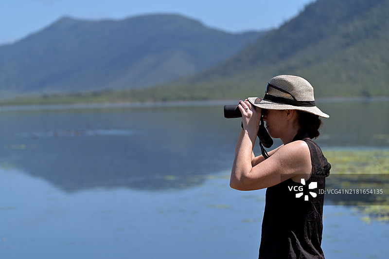 通过双筒望远镜观鸟的中年澳大利亚妇女图片素材