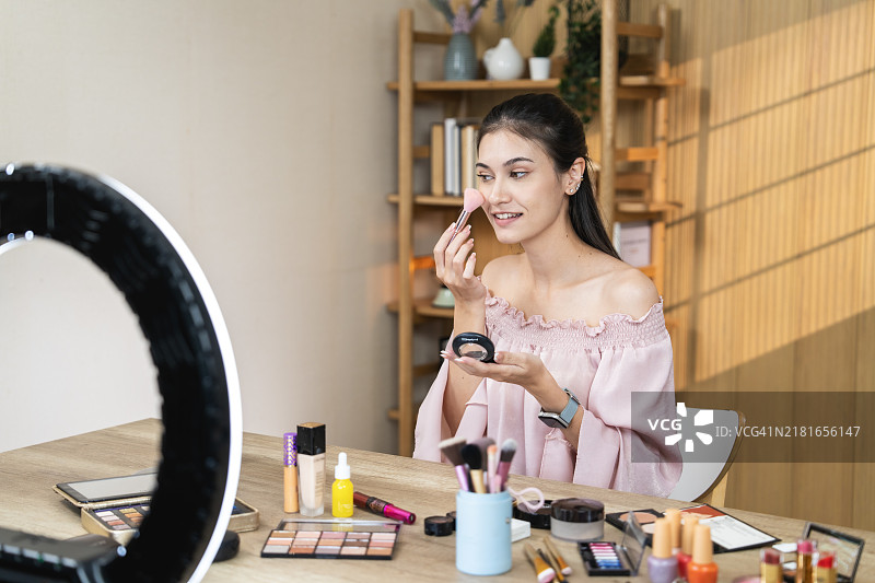 年轻女人在环形灯前化妆图片素材