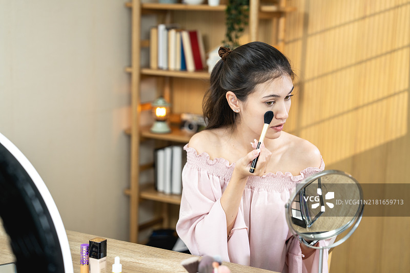 在明亮舒适的房间里化妆的年轻女人图片素材