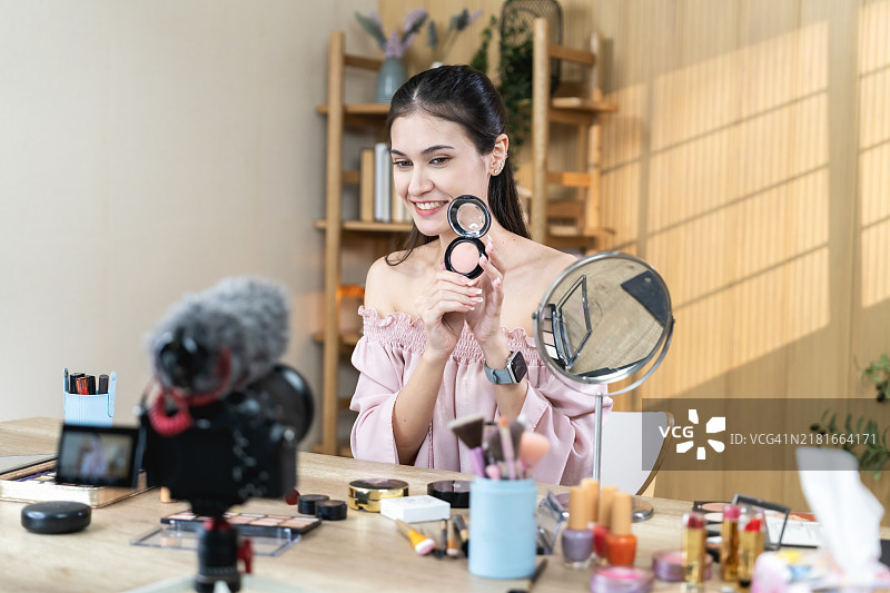 年轻女人在家庭工作室拍摄美妆教程图片素材