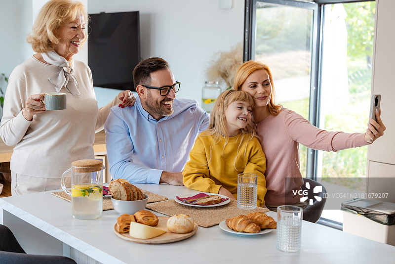 一家多代同堂的家庭在早餐时拍自拍照图片素材