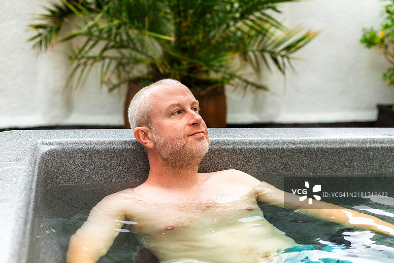 中年男人在院子里泡热水澡图片素材