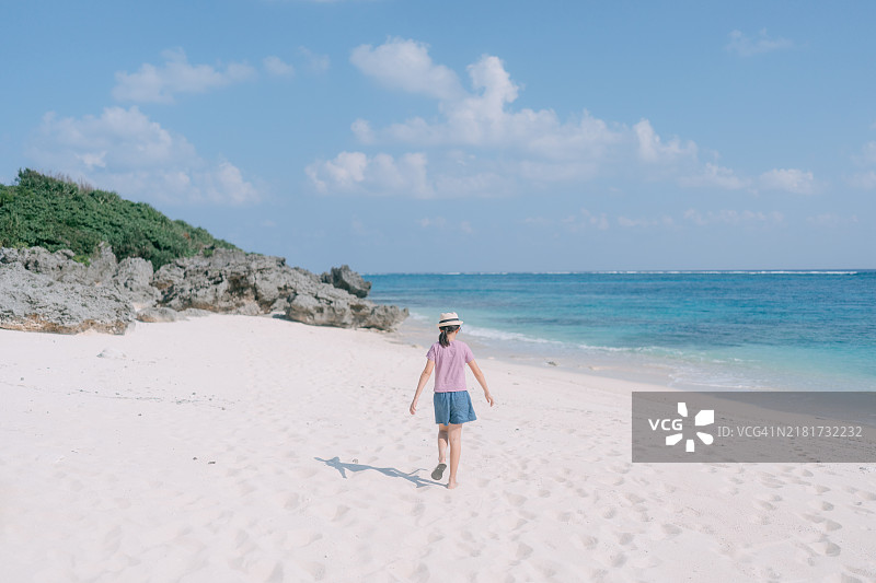 年轻女孩在白色沙滩上漫步图片素材